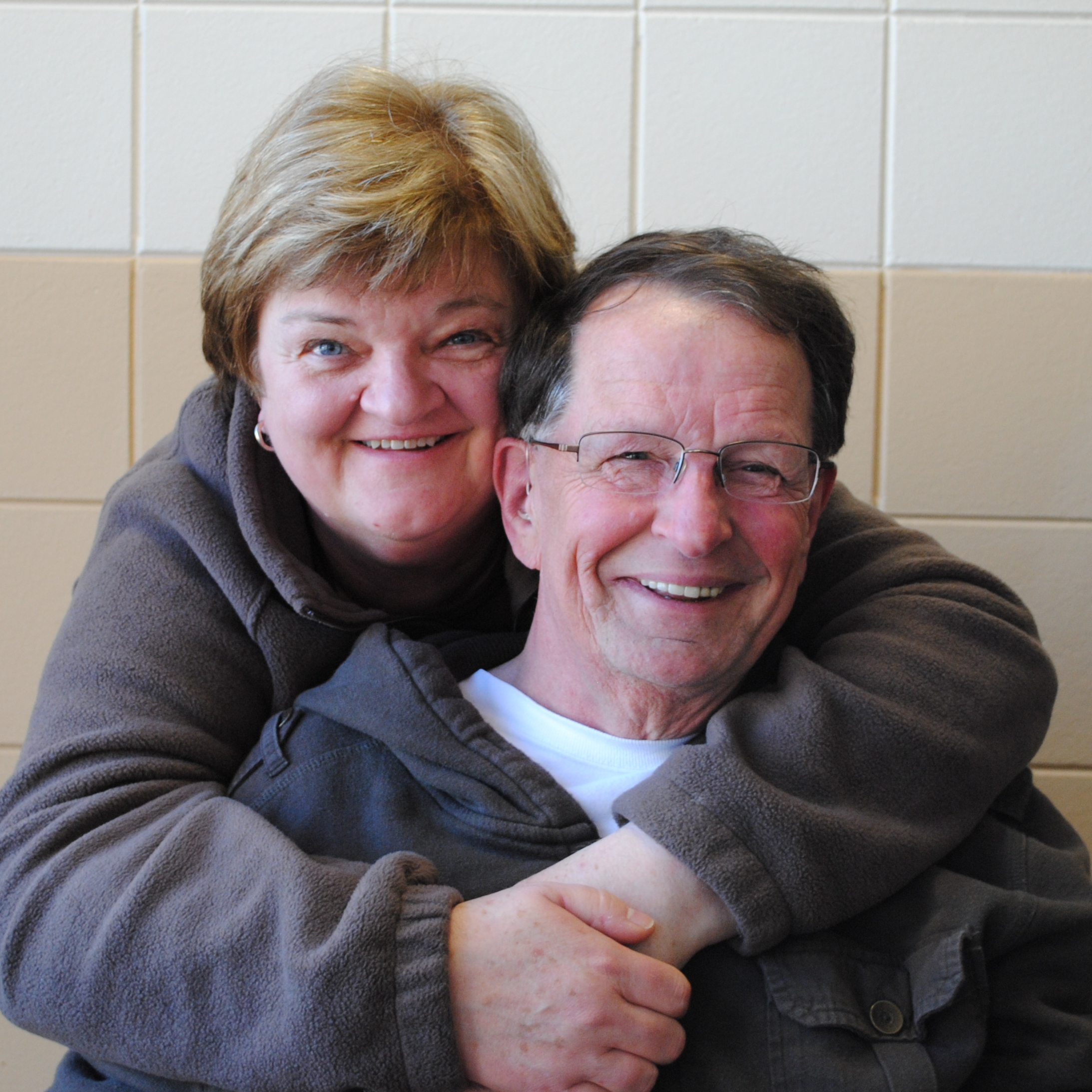 A husband and wife posing for a photo.