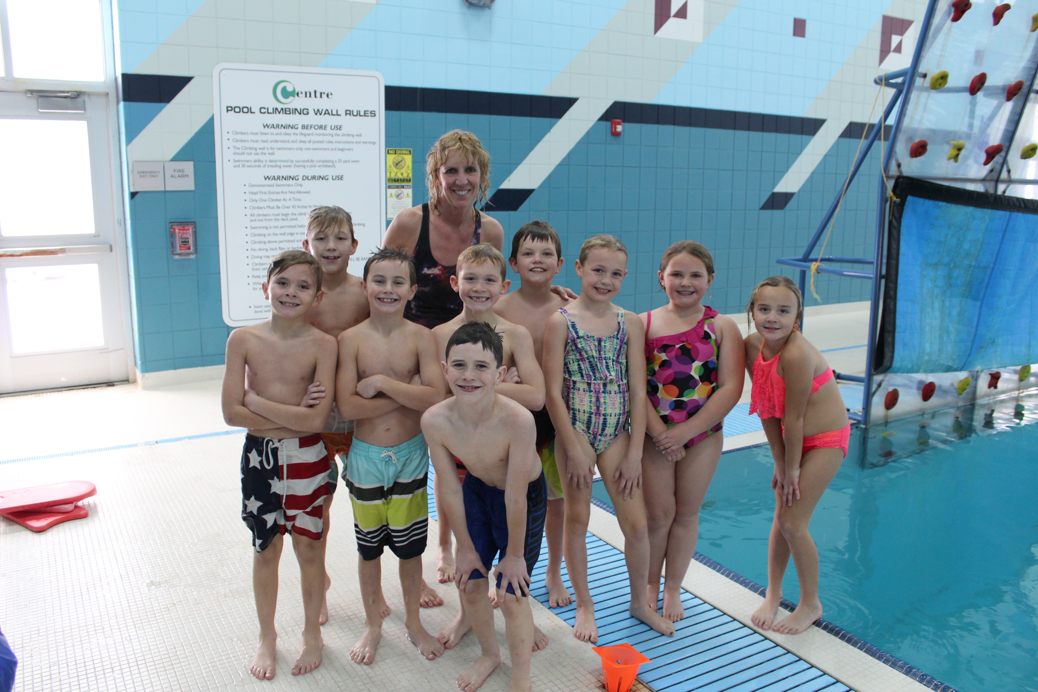 A group of kids and their instructor standing by the Centre pool